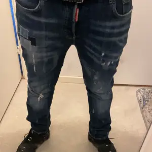 Säljer ett par snygga blå jeans från Dsquared2 i bra skick. De har en cool slitning och patch-detaljer som ger en trendig look. Perfekta för både vardag och fest! Passformen är normal och de är tillverkade i bomull för en bekväm känsla.