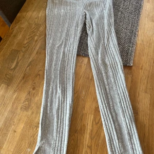 Grå ribbade byxor från Shein - Säljer ett par grå ribbade byxor från Shein i storlek Petite S. De är superbekväma och perfekta för både vardag och mysiga hemmakvällar. Byxorna har en elastisk midja och är gjorda i ett mjukt material som känns skönt mot huden.