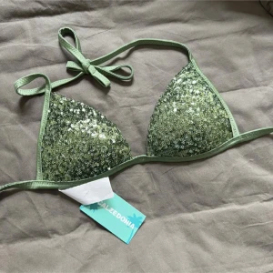 Grön glittrig bikiniöverdel från Calzedonia - Säljer denna supergulliga gröna bikiniöverdelen från Calzedonia i storlek XS som jag tror inte säljs längre. Köpt här på plick men var tyvärr för liten. 