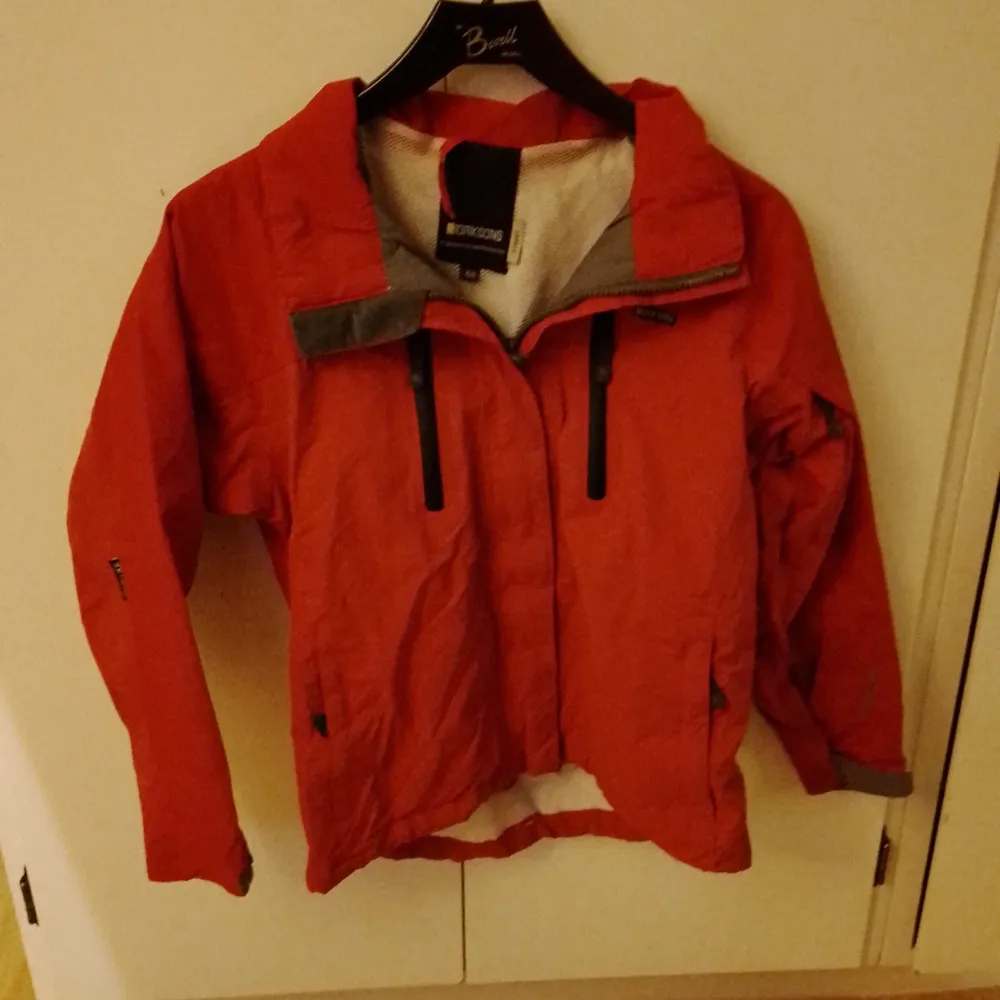 Röd jacka från didriksons i storlek 150. Gissar att den är till våren eller bara en vindjacka då den är tunn. Katt finns I hemmet. Takit.