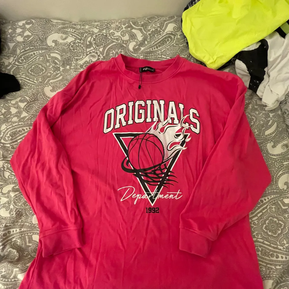 Säljer en cool rosa långärmad tröja från FB Sister med trycket 'ORIGINALS Department 1992' och en basketbollgrafik. Perfekt för en avslappnad stil eller sportiga dagar. Tröjan är i bra skick och superbekväm att ha på sig. Passar perfekt till jeans eller leggings!. Tröjor & Koftor.