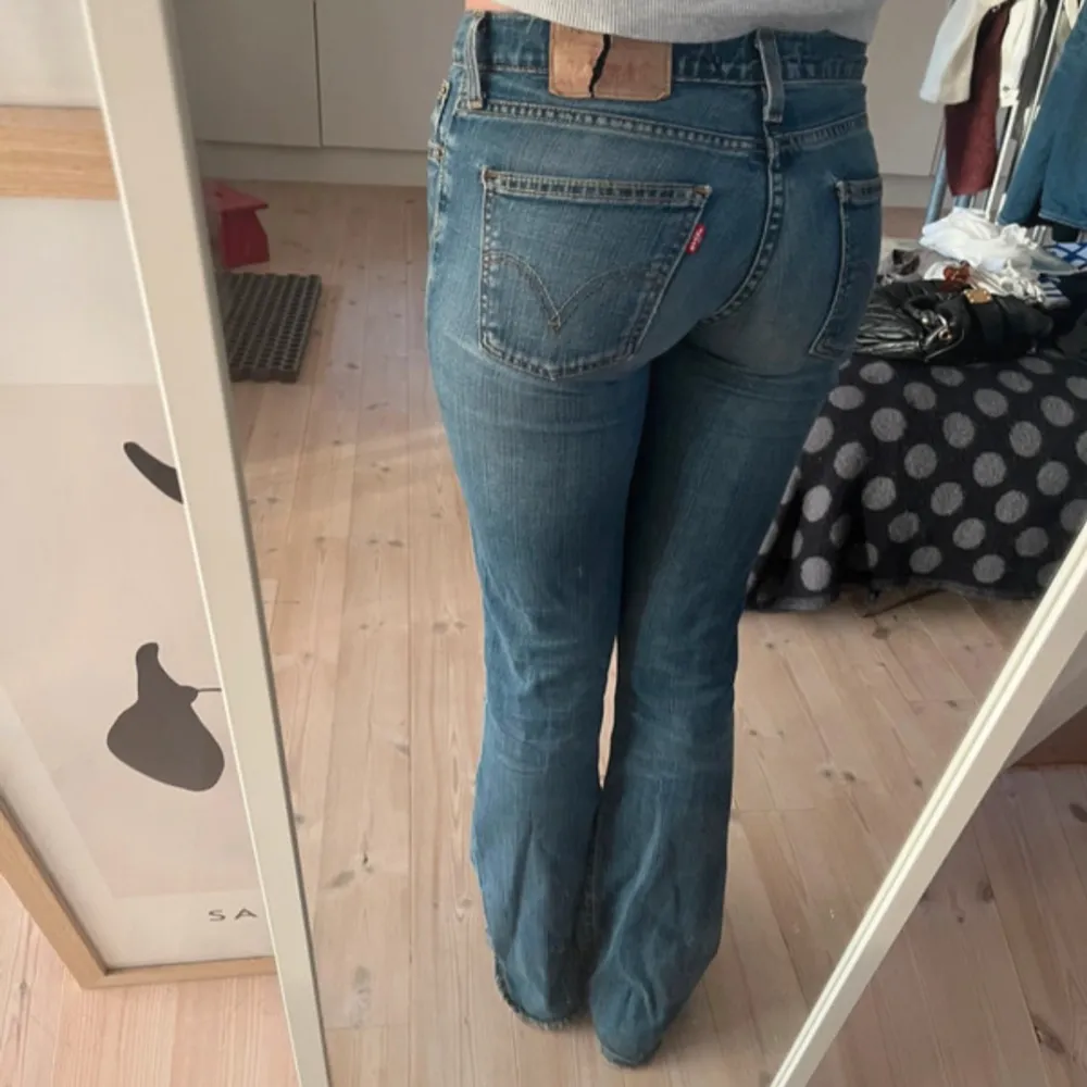 Säljer ett par snygga blå Levis jeans i bra skick ( förutom den spruckna lappen som syns på bilden ). De är lågmidjade och bootcut. Inrebenslängden är 80cm och midjemått 38cm🥰 använd gärna köp nu💕. Jeans & Byxor.