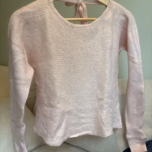 Rosa stickad tröja - Säljer en superfin rosa stickad tröja från Esprit i storlek XS. Den har en söt knytning i ryggen och är perfekt för både vår och höst. Tröjan är långärmad och har en mjuk och bekväm passform.