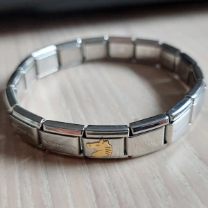 Nomination armband med hästmotiv - Säljer ett snyggt Nomination armband i rostfritt stål. Passar alla eftersom det är stretchigt.