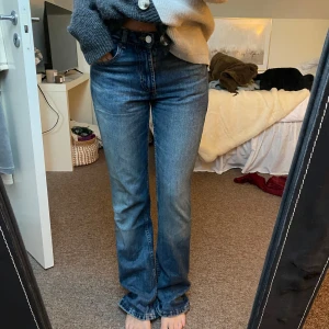 Blå jeans  - Säljer ett par snygga blå utsvängda jeans med medelhög midja. Jeansen är i mycket bra skick och passar till allt!