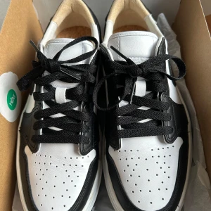 Nike Air Jordan 1 Elevate Low - Helt nya oanvända. Köpte fel storlek. Säljer ett par Nike Air Jordan 1 Elevate Low i svart och vitt. Skorna är i nytt skick och har en snygg design med svart snörning och perforerade detaljer på tån. Perfekta för både vardag och fest! Mäter 24,5cm innermått. 