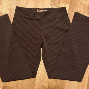 Bruna randiga kostymbyxor - Bruna randiga kostymbyxor men midjemåttet 36 cm, de är dock stretchiga så passar på många 