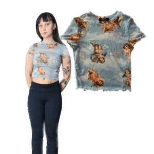 Blå mesh topp med änglamotiv - Säljer en cool blå mesh topp med änglamotiv. Den är croppad och har korta ärmar, perfekt för en unik stil. 