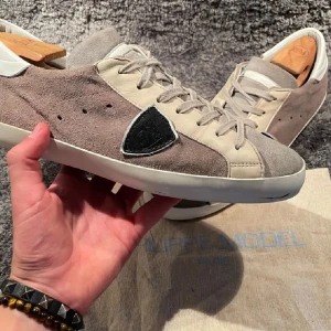 Jävligt feta fillipmodelles, väldigt unika - Säljer ett par snygga sneakers i beige och grå mocka med en unik design. Skorna har snörning och en vit sula som ger en stilren look. Perfekta för både vardag och festliga tillfällen. De är i mycket bra skick.