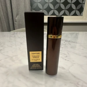 Tom Ford Tobacco Vanille Eau de Parfum - Säljer en elegant Tom Ford Tobacco Vanille Eau de Parfum. Flaskan är brun med magnetisk lock. Perfekt för den som älskar en varm och kryddig doft med inslag av tobak och vanilj. Flaskan är 10 ml och kommer i originalförpackning. Original pris 880kr, kvitto finns! Har bara använts 1 gång, 2 sprej! Den är full! Pris kan möjligtvis diskuteras 