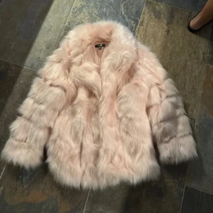 Rosa pälsjacka från Missguided - Superfin rosa pälsjacka från Missguided i storlek XS. Perfekt för att hålla sig varm och snygg under kyliga dagar. Jackan har långa ärmar och en fluffig look som ger en lyxig känsla. Passar perfekt till både vardag och fest!