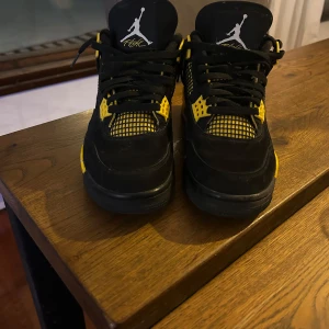 Svarta och gula Nike Air Jordans - Säljer ett par snygga Nike Air Jordans i svart och gult. Skorna har en cool design med Jumpman-loggan på tungan och hälen. Perfekta för både vardag och fest! De är i bra skick. Passa på att köpa dessa klassiker!