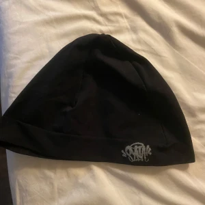 Svart syna world mössa - Syna world mössa som central cee har. Kvalite 10/10 använd 1 gång. Ny på syna world hemsida kostar 1000kr och här för bara billiga 400kr! Varför så billigt? Jo för köpte de å tänkte att ja kanske skulle passa i de men inte riktigt min stil.
