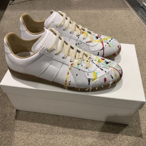 Maison margiela paint splatter - Säljer ett par Maison Margiela Paint Splatter sneakers i fint skick. Dessa har legat i garderoben inte använts något. Perfekt tillfälle för dig som vill ha något unikt i garderoben. Kontakta mig om du är intresserad!