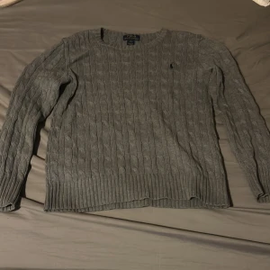 Grå stickad tröja från Polo Ralph Lauren - Säljer en snygg grå stickad tröja från Polo Ralph Lauren då den blivit för liten. Storlek L i barnstorlek.