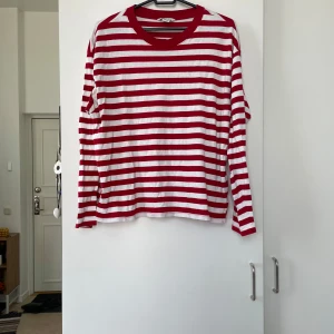 Röd- och vitrandig tröja från Monki - Säljer en superfin röd- och vitrandig tröja från Monki i storlek S. Den är perfekt för både vinter och vår med sina långa ärmar och mjuka bomullsmaterial. Tröjan har en klassisk rund halsringning och är i mycket bra skick. Perfekt för en casual look! 🌟