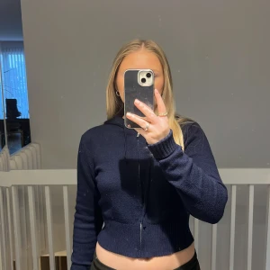 Mörkblå stickad hoodie från Nelly - Säljer en superfin mörkblå stickad hoodie från Nelly. Den är croppad med dragkedja och har en mysig huva. Perfekt för höst och vinter när du vill vara både varm och stilren. Passar perfekt till jeans eller leggings. Använd ett fåtal gånger, så den är i mycket bra skick. 💙Strolek L men sitter som en S då den e väldigt croppad, nypris: 399kr
