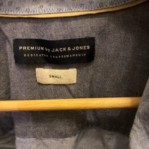 Blå skjorta från Jack & Jones - Säljer en snygg blå skjorta från Jack & Jones i storlek small. Skjortan har ett diskret prickigt mönster och är långärmad med knappar framtill. Perfekt för både vardag och fest! 💙
