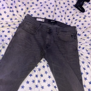 Grå jeans från Replay - Säljer ett par snygga grå jeans från Replay i modellen Anbass. De är i bra skick och har en modern slim passform. Perfekta för både vardag och fest! 🖤