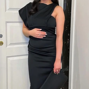 Svart oneshoulder klänning - Elegant svart oneshoulder klänning i tight passform. Perfekt för festliga tillfällen med sin stilrena design. Klänningen har en asymmetrisk axel och lång.