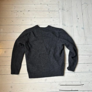 Mörkgrå stickad tröja från Zara - Säljer en stilren mörkgrå tröja från Zara i storlek L som också passar M. Tröjan är perfekt för kyliga dagar med sin mjuka och varma känsla. Den har långa ärmar och ribbade muddar vid ärmslut och nederkant. Passar både till vardags och lite finare tillfällen.