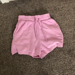 Rosa shorts med resårmidja - Säljer ett par superbekväma rosa shorts med resårmidja. Perfekta för en avslappnad dag hemma eller en promenad i solen. De har en loose passform och är gjorda i ett mjukt material som känns skönt mot huden. Passar perfekt till sommaren! 💖