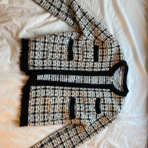 Svartvit rutig jacka från Zara - Säljer en snygg svartvit rutig jacka från Zara i storlek S. Jackan har långa ärmar och en stilren design med svarta kanter och fransiga detaljer. Perfekt för höst och vår, och funkar både till vardags och fest. 🖤🤍