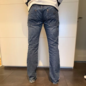Blå Armani jeans i bra skick - Säljer ett par klassiska blå Armani jeans i bra skick. De har en normal passform och är perfekta för vardagsbruk. Jeansen har en midwaist och är tillverkade i ett slitstarkt denimtyg. Perfekta för både höst och vår!