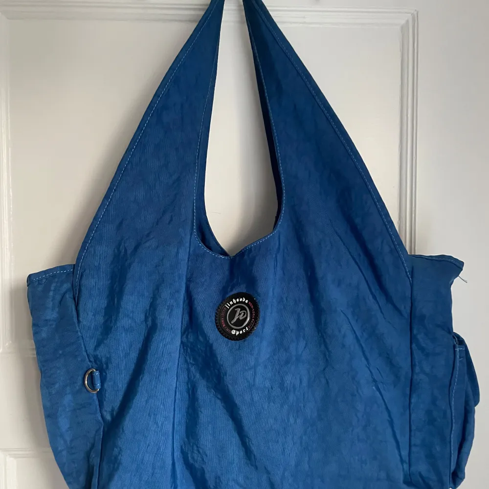 Säljer en snygg blå axelväska från JPNY. Väskan har en praktisk design med tre stora huvudfack och en mindre ficka med dragkedja på baksidan. Perfekt för vardagsbruk eller en dag på stan. Den är i bra skick och redo för nya äventyr! 💙. Laukut & Käsilaukut.