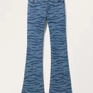 Blå zebramönstrade bootcut jeans - Säljer ett par unika blå bootcut jeans med zebramönster. De är perfekta för att sticka ut och ge en cool touch till din outfit. Passar bra till både vardag och fest!