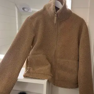 Mysig beige teddyjacka i mycket bra skick. Perfekt för höst och vinter med dragkedja framtill och långa ärmar. Jackan är supermjuk och håller dig varm under kyliga dagar. I storlek S/34