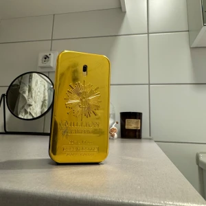 Rabanne 1 million Edp 50ml - Säljer en lyxig parfymflaska i guld från Paco Rabanne. Flaskan har en elegant och modern design med en glansig yta och detaljer i relief. Perfekt för den som vill ha en doft med stil och attityd. Flaskan är i gott skick och redo att användas. Innehåller ca 48ml