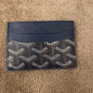 Mönstrad kortplånbok - Säljer en snygg och kompakt kortplånbok med ett coolt mönster. Den är blå med ett unikt mönster i vitt och blåa Perfekt för att hålla dina kort organiserade. Insidan är gul, vilket ger en fin kontrast. Passar perfekt i fickan!