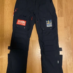 Skidbyxor - Skidbyxor som är använda vid endast två tillfällen så nästan helt nya. Ny priset är runt 3500 men detta är också utan team Sverige märket. Storlek L. Den ända skavanken som finns är att de är en liten reva längst ner på vänstra benet. 