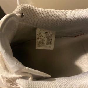 Vita Nike Air Force sneakers - Säljer ett par klassiska vita Nike Air Force sneakers i storlek herr 43. De är i nytt skick och har snygg snörning. Perfekta för alla tillfällen och ger en stilren look. Passar både till vardags och fest!