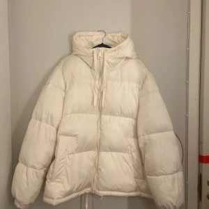 Vit pufferjacka från H&M - Säljer en supermysig vit pufferjacka från H&M i storlek M. Perfekt för kalla vinterdagar med sin varma och vadderade design. Jackan har en dragkedja framtill och en skön huva för extra skydd mot kylan. Den är i mycket bra skick och prfekt för vintern! ❄️