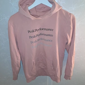 Rosa hoodie från Peak Performance - Säljer för att den är för liten för mig😊 en superfin rosa hoodie från Peak Performance i storlek 160. Den är i bra skick och har en mysig känguruficka framtill. Perfekt för både höst och vår! 💖