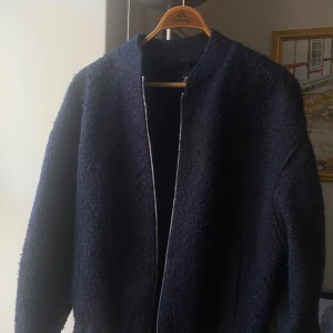 Mörkblå teddyjacka - Säljer en supermysig oversized mörkblå teddyjacka med dragkedja. Perfekt för kyliga höst- och vinterdagar. Jackan har en normal passform och långa ärmar. Den är i mycket bra skick!