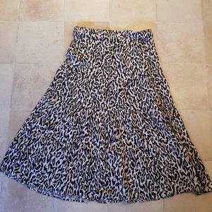 Leopardmönstrad kjol från Gina Tricot - Säljer en superfin leopardmönstrad kjol från Gina Tricot i storlek 38. Kjolen har en luftig passform och är perfekt för både vardag och fest. Den är gjord i ett lätt och bekvämt material som faller snyggt. 🐆✨