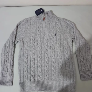 Grå stickad Polo Ralph Lauren tröja - Säljer en snygg grå stickad tröja från Polo Ralph Lauren. Tröjan är helt ny i skick. Säljer den då den är lite stor för mig. Den har storleken L men kan passa som M. Nytt i internet kostar 2000kr. Priset kan diskuteras vid snabb affär.