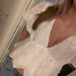Vit blus  - Super snygg vit v-ringad blus med volanger och ett unikt och skit snyggt tyg🫶🏼