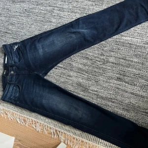 Mörkblå replay Anbass - Säljer ett par snygga mörkblå jeans från Replay i bra skick. De har en klassisk femficksdesign och en bekväm passform. Perfekta för både vardag och fest! 🕺