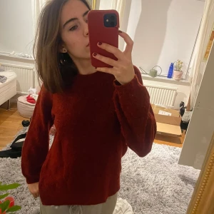 Röd stickad tröja från Indiska - Mysig röd stickad tröja från Indiska i storlek S. Perfekt för höst och vinter med sin varma och bekväma design. Tröjan har långa ärmar och en klassisk passform som passar till alla tillfällen. Ett måste i garderoben för kyliga dagar! 🍂