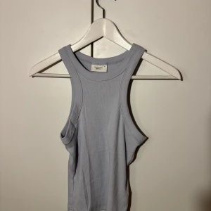 Ljusblå ribbad linnetopp - Säljer en superfin ljusblå ribbad linnetopp från Zara. Perfekt för sommardagar eller som ett lager under en jacka. Toppen är ärmlös och har en tight passform som framhäver figuren. Den är i mycket bra skick och redo för nya äventyr!