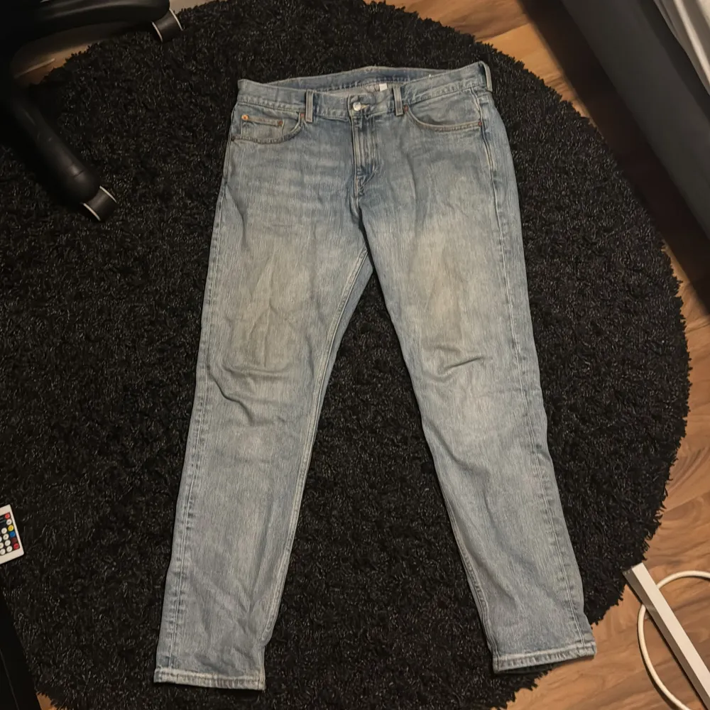 Säljer ett par ljusblå jeans från Weekday i bra skick. De har en klassisk straight fit och är perfekta för vardagsbruk. Jeansen har en knappgylf och fem fickor. Passar perfekt till både t-shirt och skjorta. Perfekt för både vår, sommar och vinter.. Jeans & Byxor.