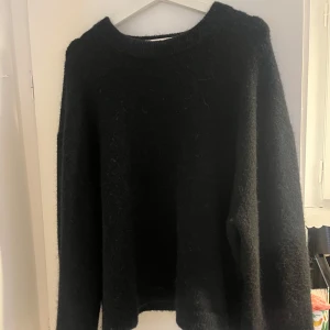 Svart ulltröja - Mysig svart ulltröja perfekt för kyliga dagar. Den har en enkel design med långa ärmar och rund hals. Passar både till vardags och lite finare tillfällen. Ett måste i garderoben för höst och vinter!