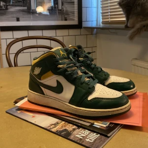 Nike Air Jordans 1 sonics - Säljer ett par Nike Air Jordans Sonics, Skorna har en klassisk design med snörning och är i bra skick. Perfekta för både vardag och sportiga aktiviteter. Sulan är grön och ovandelen har snygga detaljer i gult. Du får med boxen. Skorna är äkta. Jag säljer för att dom inte längre kommer till användning. Hör av dig för mer frågor!👌🏻🫡