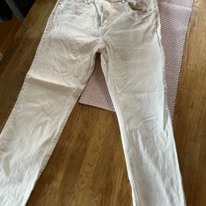 Beige byxor från H&M - Säljer ett par beige byxor från H&M i bra skick. De är i en normal passform och har en klassisk stil med fickor både fram och bak. Perfekta för vardagsbruk och kan enkelt matchas med olika toppar. Passar bra till både vår och höst.