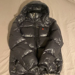 Svart pufferjacka från Polo Ralph Lauren - Säljer en snygg svart pufferjacka från Polo Ralph Lauren i mycket bra skick. Har använts fåtal gånger. Perfekt för kommande vinter!❄️ Hör av dig vid frågor!