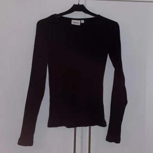 Svart långärmad tröja - Säljer en stilren svart långärmad tröja från Kappahl. Perfekt för vardag. Tröjan har en tight passform och är gjord i ett mjukt material som känns skönt mot huden. Passar bra till jeans eller kjol för en snygg look. 🖤